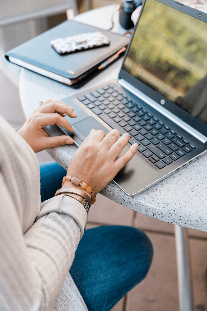 A woman typing on her laptop while sitting at a table
