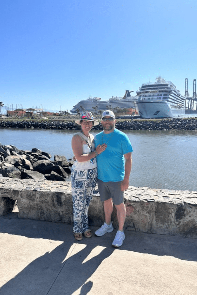 My husband and i standing in front of a cruise ship